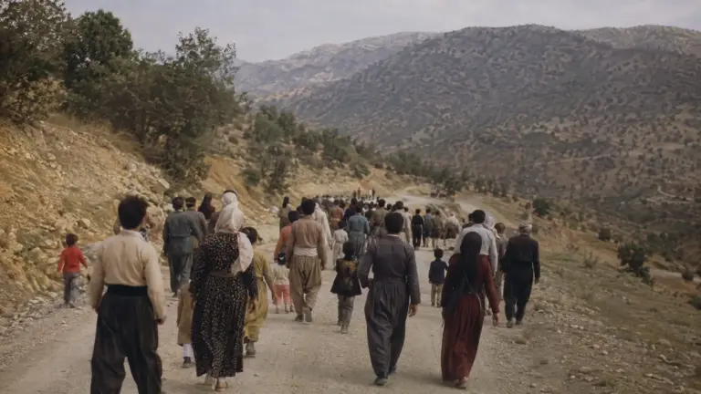 گروهی از مردم در حال حرکت در جادهای کوهستانی در کردستان